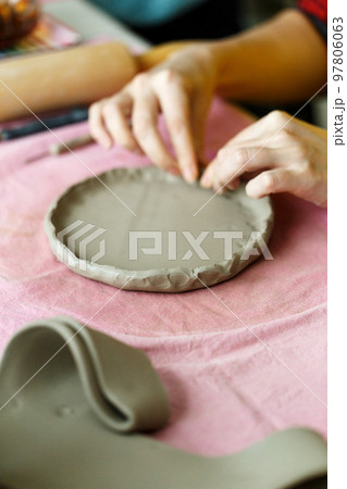 Pottery workshop class. A pottery crafts dish from a raw clay. Creating ceramics Pottery workshop class. A pottery crafts dish from a raw clay. Creating ceramics 97806063