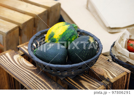 Round green zucchini in wicker plate on wooden background. Round green zucchini in wicker plate on wooden background. 97806291