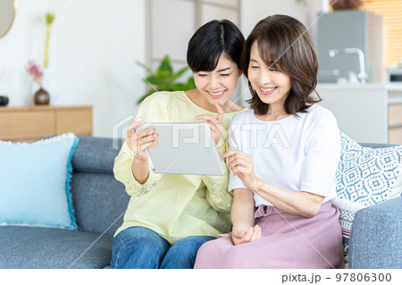 リビングでタブレットを操作する親子 リビングでタブレットを操作する親子 97806300
