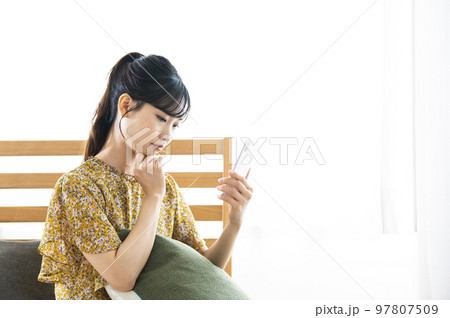 スマホ　若い女性　検索　調べる　不安　悩み　ベットルーム 97807509