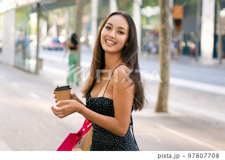 Optimistic female shopaholic with coffee to go 97807708