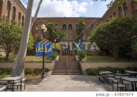 Los Angeles, USA. September 20, 2022. Steps amidst trees leading towards entrance of historic UCLA building with posters on streetlights and furniture arranged in campus 97807974