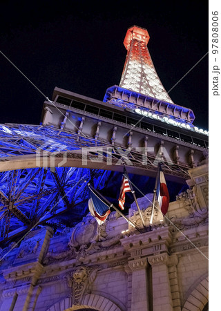 Las Vegas, USA. September 16, 2022. Low angle view of illuminated Replica of Eiffel tower and Paris Las Vegas Hotel. Flags waving at luxurious casinos in Las Vegas city during night. Las Vegas, USA. September 16, 2022. Low angle view of illuminated Replica of Eiffel tower and Paris Las Vegas Hotel. Flags waving at luxurious casinos in Las Vegas city during night. 97808006