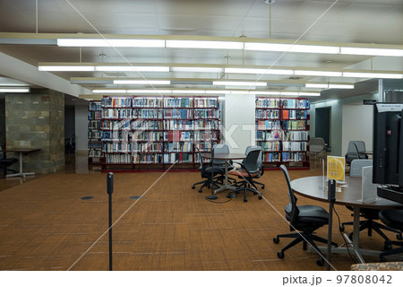 Los Angeles, USA. September 20, 2022. Books on shelves with empty chairs and tables on hardwood floor in illuminated library at UCLA Los Angeles, USA. September 20, 2022. Books on shelves with empty chairs and tables on hardwood floor in illuminated library at UCLA 97808042