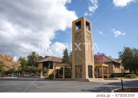 The Stanford Clock Tower with attached colonnaded pergolas at Stanford University campus under cloudy sky during sunny day at Palo Alto in California 97808309
