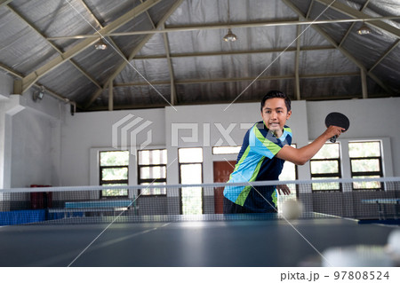 Asian male athlete hitting in a ping pong match 97808524