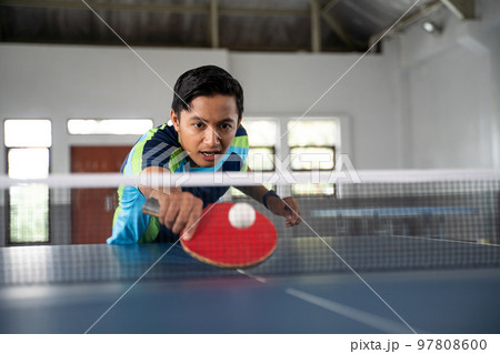 Male ping pong player trying to swing the ball Male ping pong player trying to swing the ball 97808600