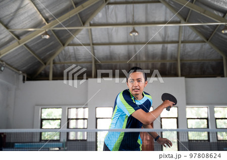 male athlete backhand hitting in a ping pong match 97808624