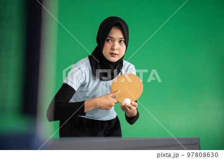 Muslim female table tennis player holding ball preparing to serve 97808630