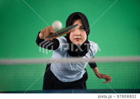Asian Muslim female athlete hits the ball back Asian Muslim female athlete hits the ball back 97808802