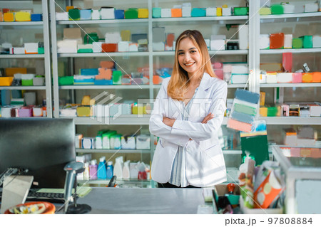 beautiful pharmacist in uniform smiling at camera with crossed hands 97808884