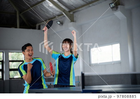 male and female asian ping pong players happy to score 97808885