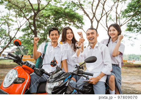 Happy high school students with clenched fists celebrating graduation 97809070