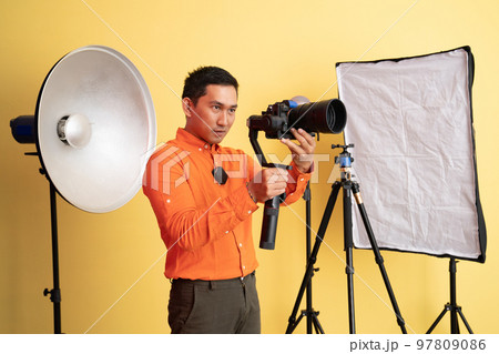 vlogger standing taking photo using professional camera with stabilizer vlogger standing taking photo using professional camera with stabilizer 97809086