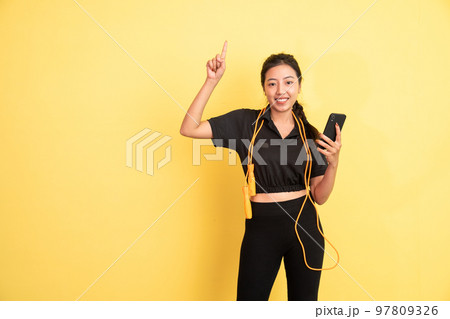 woman holding cell phone with finger pointing up 97809326