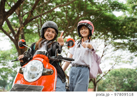 Two student girls with thumbs up to the camera Two student girls with thumbs up to the camera 97809518
