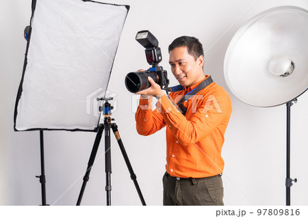 photographer takes a photo using a professional camera with lighting 97809816