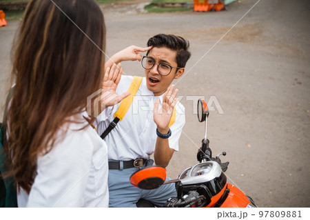 Male student in glasses scared when threatened by a girl Male student in glasses scared when threatened by a girl 97809881