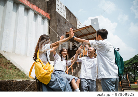 Asian high school students holding hands while forming a union Asian high school students holding hands while forming a union 97809928