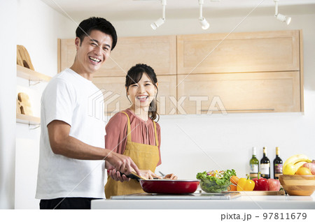 料理をする若い夫婦 カメラ目線 料理をする若い夫婦 カメラ目線 97811679