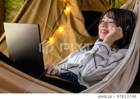 ワーケーション　キャンプ場で仕事をする若い女性 97813746