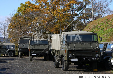 秋晴れの自衛隊駐屯地、駐車場の一角の73式中型トラック 97816315