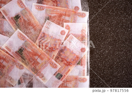 Five thousand rubles are thawed in ice. The Russian currency is frozen. Five thousand rubles are thawed in ice. The Russian currency is frozen. 97817556