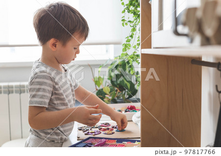 Baby boy creating plasticine diy figure with decorate dried beans element early development top view Baby boy creating plasticine diy figure with decorate dried beans element early development top view 97817766