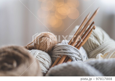 Cozy homely atmosphere. Female hobby knitting. Yarn in neutral colors. Cozy homely atmosphere. Female hobby knitting. Yarn in neutral colors. 97817808