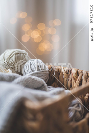 Cozy homely atmosphere. Female hobby knitting. Yarn in grey colors in a basket 97817810