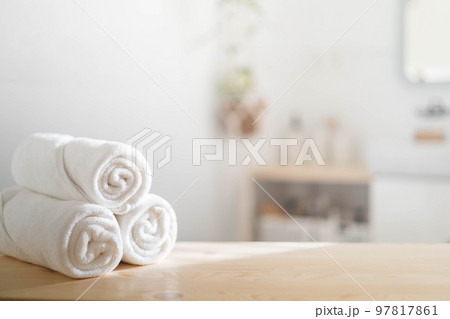 White rolled towels on wooden countertop spa beauty body care hygiene procedure at bathroom.  97817861