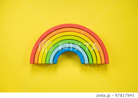 Wooden multicolored rainbow Montessori material for kids early development isolated on yellow 97817945