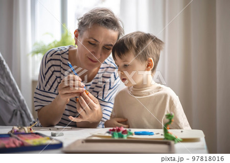 Caring mother sculpt dinosaurs from plasticine early development with boy and girl kids 97818016