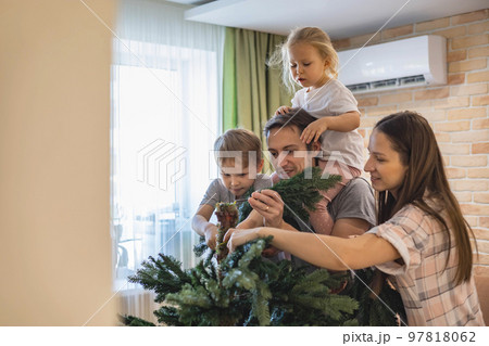 Family assembling, shaping hook-in artificial Christmas Tree at home Family assembling, shaping hook-in artificial Christmas Tree at home 97818062