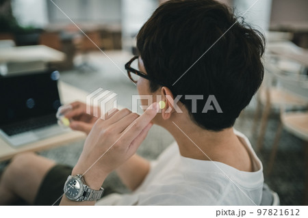 耳栓をするコワーキングスペースの利用者 97821612