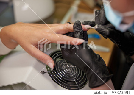 milling cutter, Manicure process, Processing nails. Process of painting nails in beauty salon, cleaning of nails with milling cutter, removing nail plate with milling machine 97823691