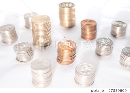 積み上げた10円玉の上でバカンスを楽しむ男性 積み上げた10円玉の上でバカンスを楽しむ男性 97829609