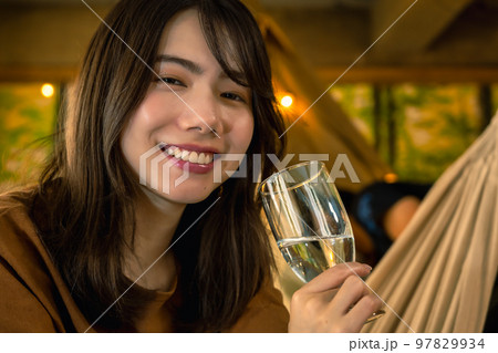 キャンプでワインを片手にくつろぐ若い女性 キャンプでワインを片手にくつろぐ若い女性 97829934