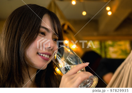 キャンプでワインを片手にくつろぐ若い女性 キャンプでワインを片手にくつろぐ若い女性 97829935