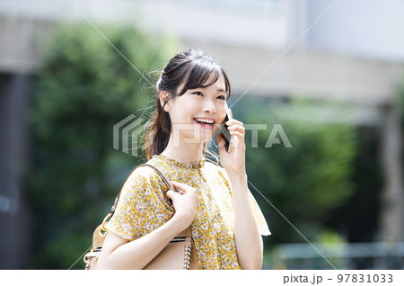 街中で電話をする若い女性 97831033