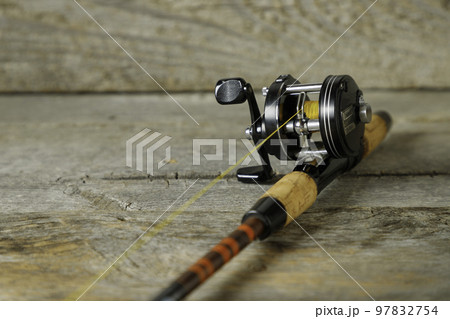 テーブルの上に置かれた釣り竿とリール 97832754