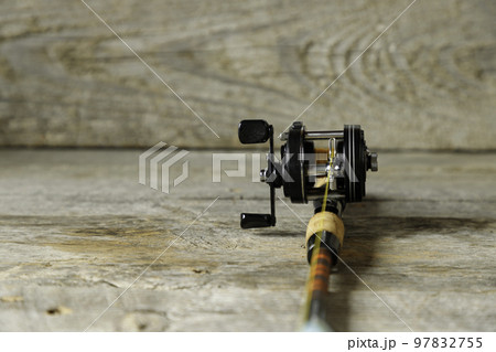 テーブルの上に置かれた釣り竿とリール 97832755