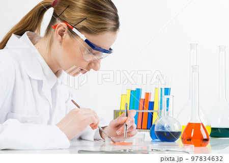 Microbiologist researching sample in petri dish. Microbiologist researching sample in petri dish. 97834632