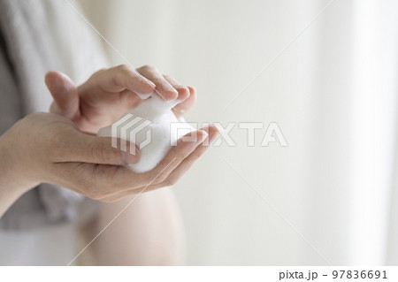 泡立てた洗顔フォームをのせた若い男性の手元 97836691