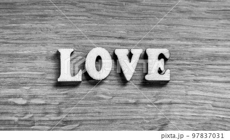 Love - word inscription of 3D wooden letters on the wood textured board background. Expression of romantic theme or Valentines Day. Rustic style inscription. Black and white image. Love - word inscription of 3D wooden letters on the wood textured board background. Expression of romantic theme or Valentines Day. Rustic style inscription. Black and white image. 97837031