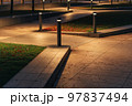 Row Of Outdoor Landscape Hard Paving Light. Lighting element on the green lawn along the footpath. Modern lighting system in landscape design. 97837494