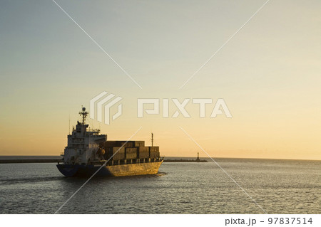 A container ship is sailing on the sea at sunset 97837514