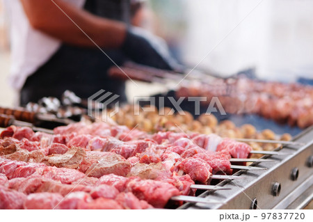 Shish kebab from pork and beef roast on coals. Barbecue in open air. Traditional meat cooking. Shish kebab from pork and beef roast on coals. Barbecue in open air. Traditional meat cooking. 97837720