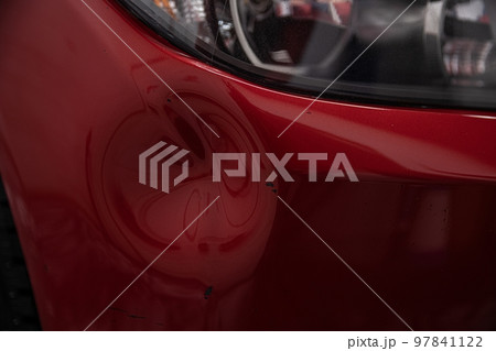 Dent on the bumper of a red car for repair 97841122