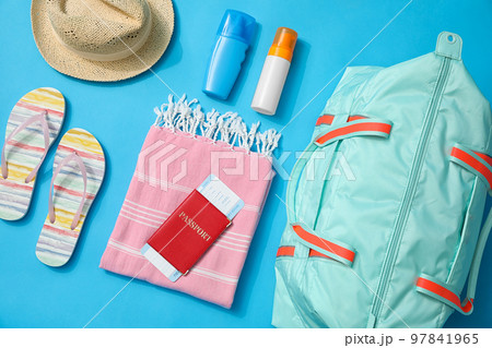 Flat lay composition with bag and travel accessories on blue background 97841965